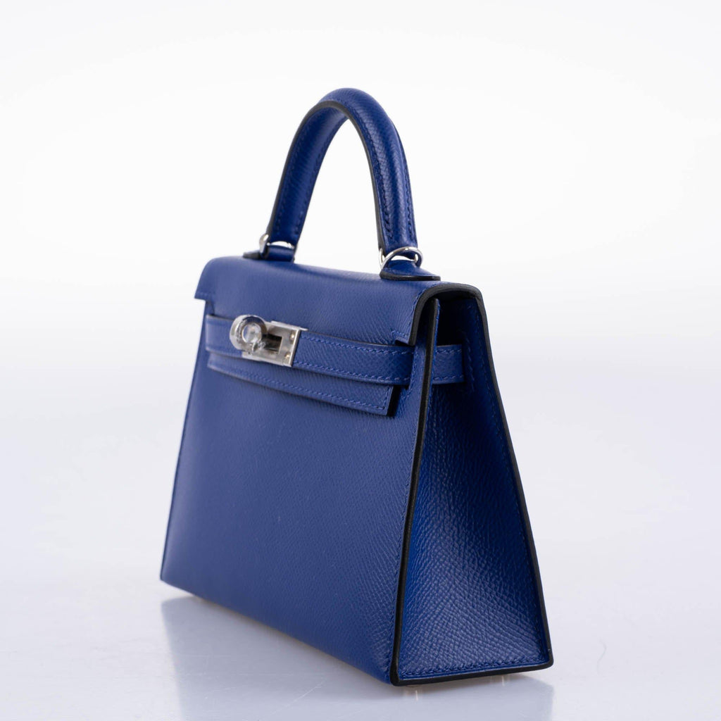 Blue handbag with a silver clasp on a white background