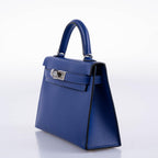 Blue handbag with a silver clasp on a white background