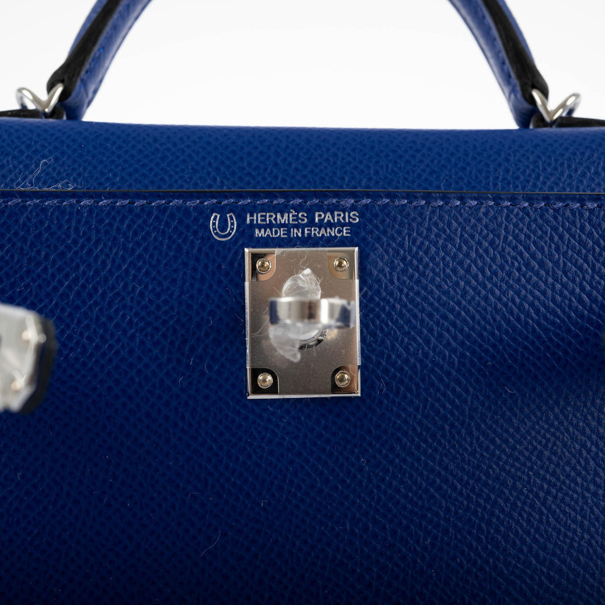 Blue handbag with Hermès Paris logo and 'Made in France' stamp on a white background