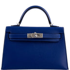 Blue handbag with a silver clasp on a white background