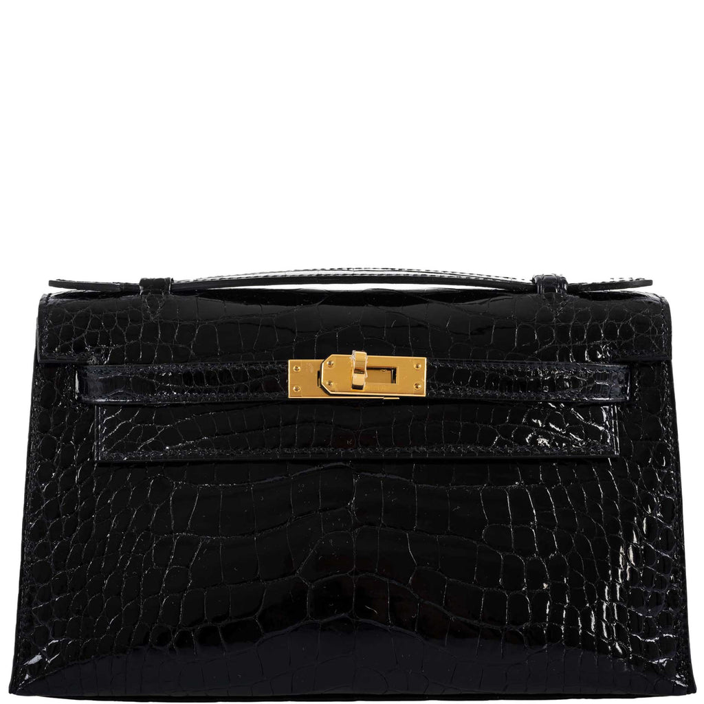 Black crocodile skin handbag with a gold clasp on a white background