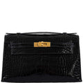 Black crocodile skin handbag with a gold clasp on a white background