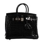 Close-up of palladium lock and strap on Birkin 25 crocodile bag