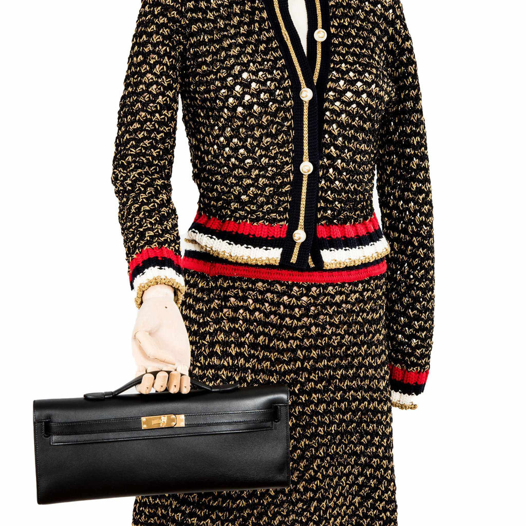 Side profile of Hermes Kelly Cut black Swift leather clutch.