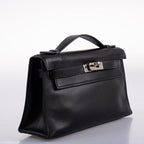 Angled shot of Hermes Kelly Mini Pochette black Swift with palladium hardware.