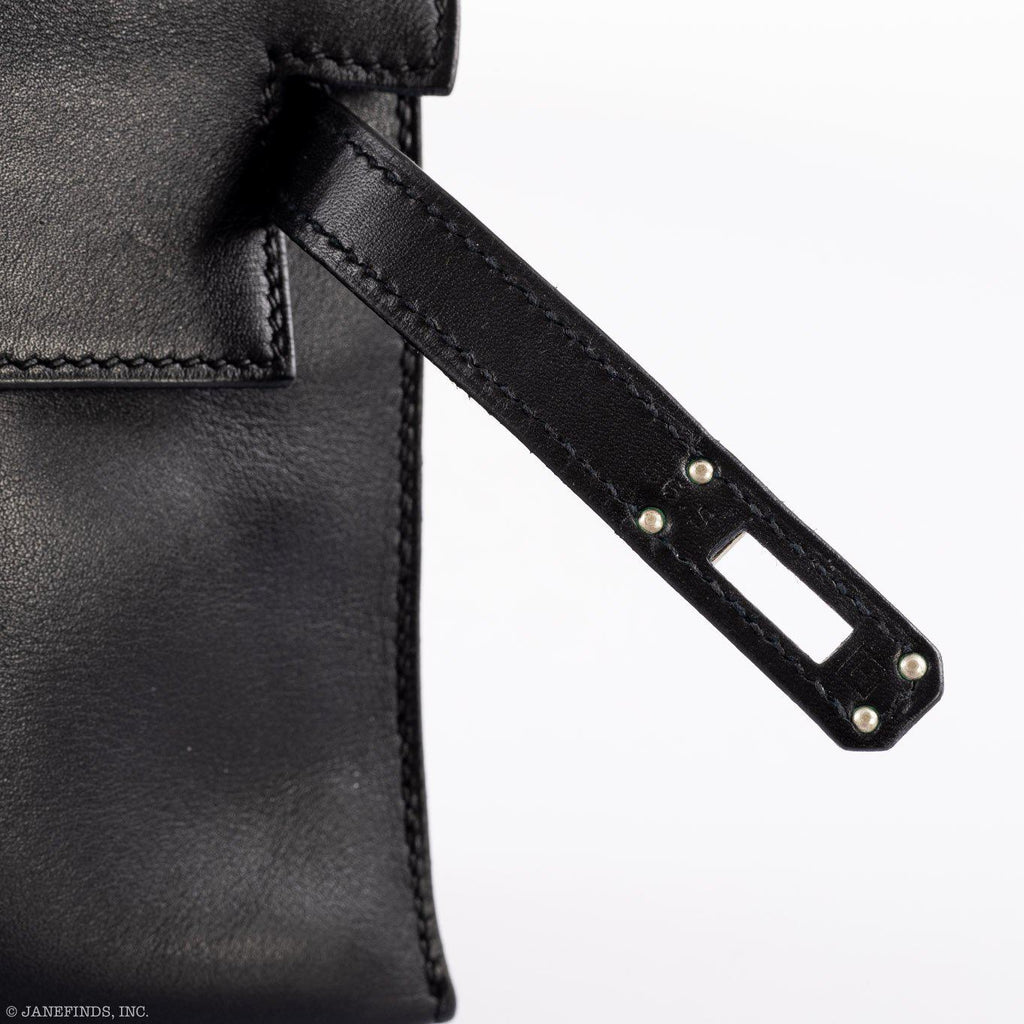 Luxury display of Hermes Kelly Mini Pochette in black Swift leather.