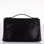 Close-up of palladium hardware and handle on Hermes Kelly Mini Pochette black Swift.
