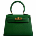 A detailed view of the gold-tone clasp and turn-lock closure on the Hermes Kelly Mini Pochette
