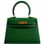 A detailed view of the gold-tone clasp and turn-lock closure on the Hermes Kelly Mini Pochette