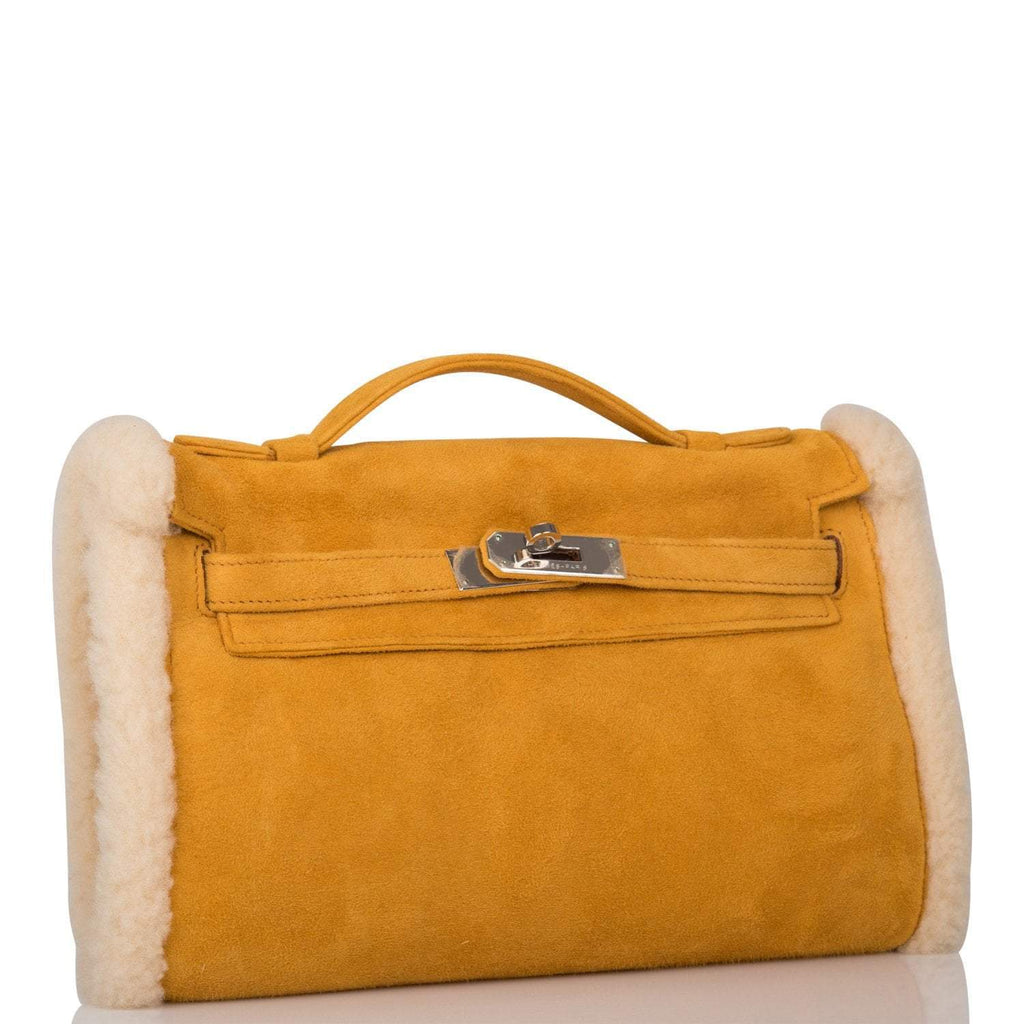Side profile of Hermes shearling muff with palladium hardware