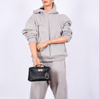 A detailed view of the protective metal feet on the bottom of the Hermes Kelly Mini Pochette