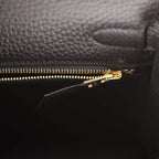 The clochette, lock, and keys in gold-tone hardware hanging from the handle