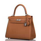 The Hermes Kelly Retourne 25 in Gold Togo leather displayed on a surface