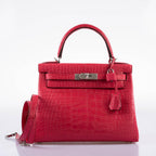 The Hermes Kelly Retourne 25 in Framboise Togo being carried on the forearm.