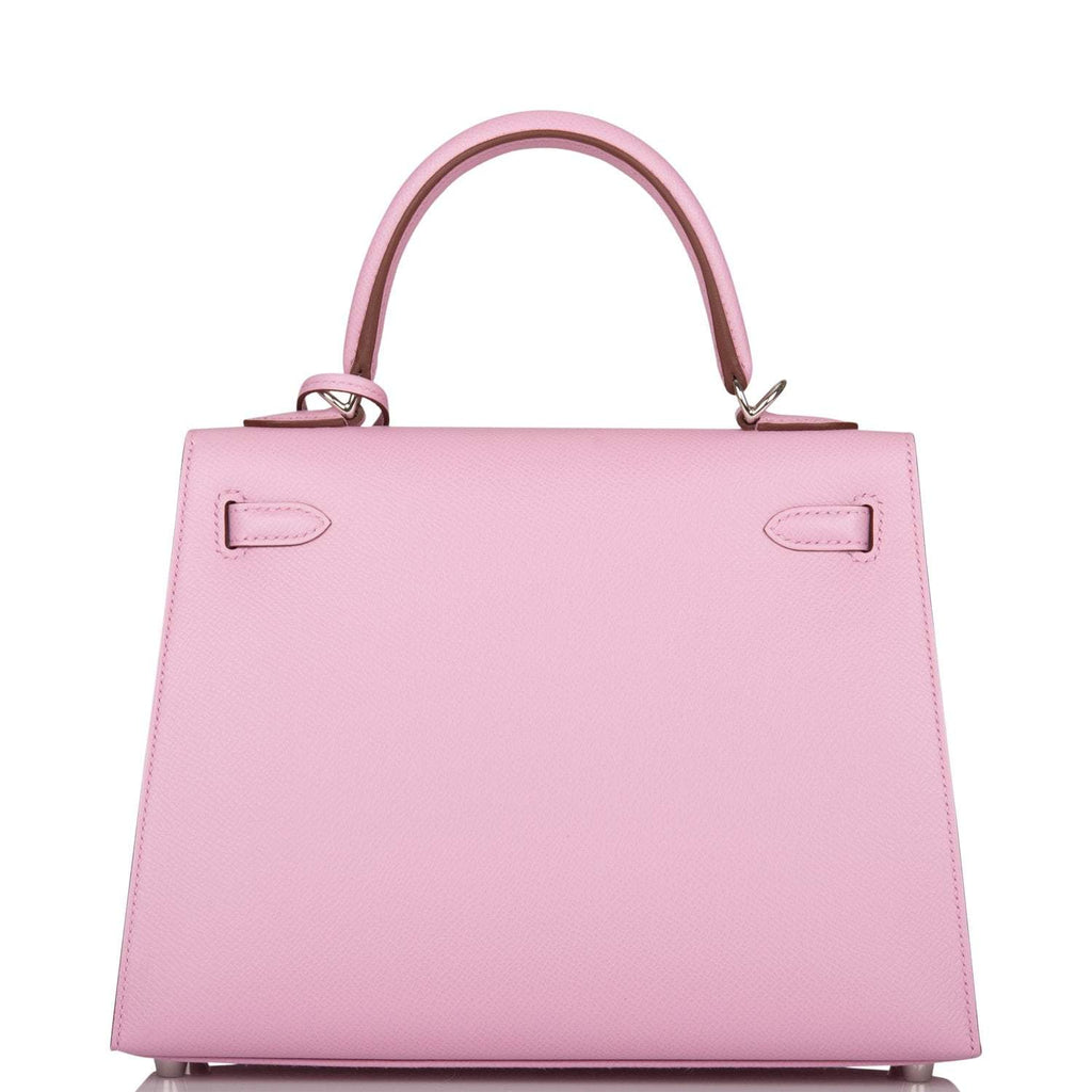 The Mauve Sylvestre Epsom Kelly 25 being held by a hand, showing its compact scale