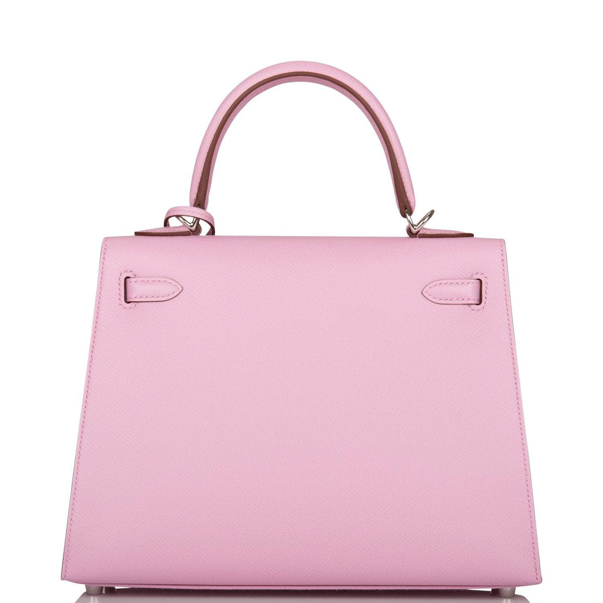The Mauve Sylvestre Epsom Kelly 25 being held by a hand, showing its compact scale