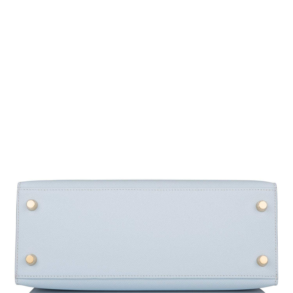 The bag being carried by hand, showcasing its compact size and handle drop