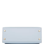 The bag being carried by hand, showcasing its compact size and handle drop