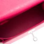 The Rose Tyrien Ostrich Kelly 25 being held by a hand, showing its compact scale