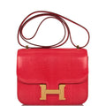 Hermes Mini Constance 18 handbag in Rouge Exotique Niloticus lizard with gold hardware.