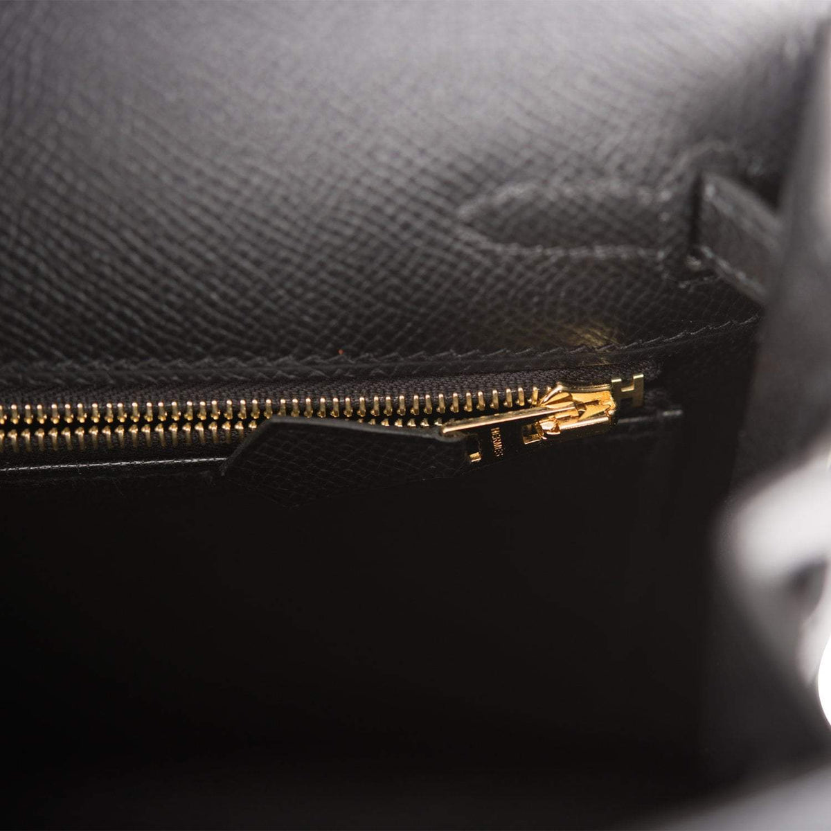 Bottom base view showing gold feet and stitching detail