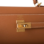 Model holding the Kelly 25 bag with shoulder strap attached