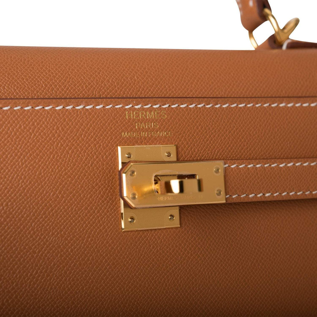 Model holding the Kelly 25 bag with shoulder strap attached